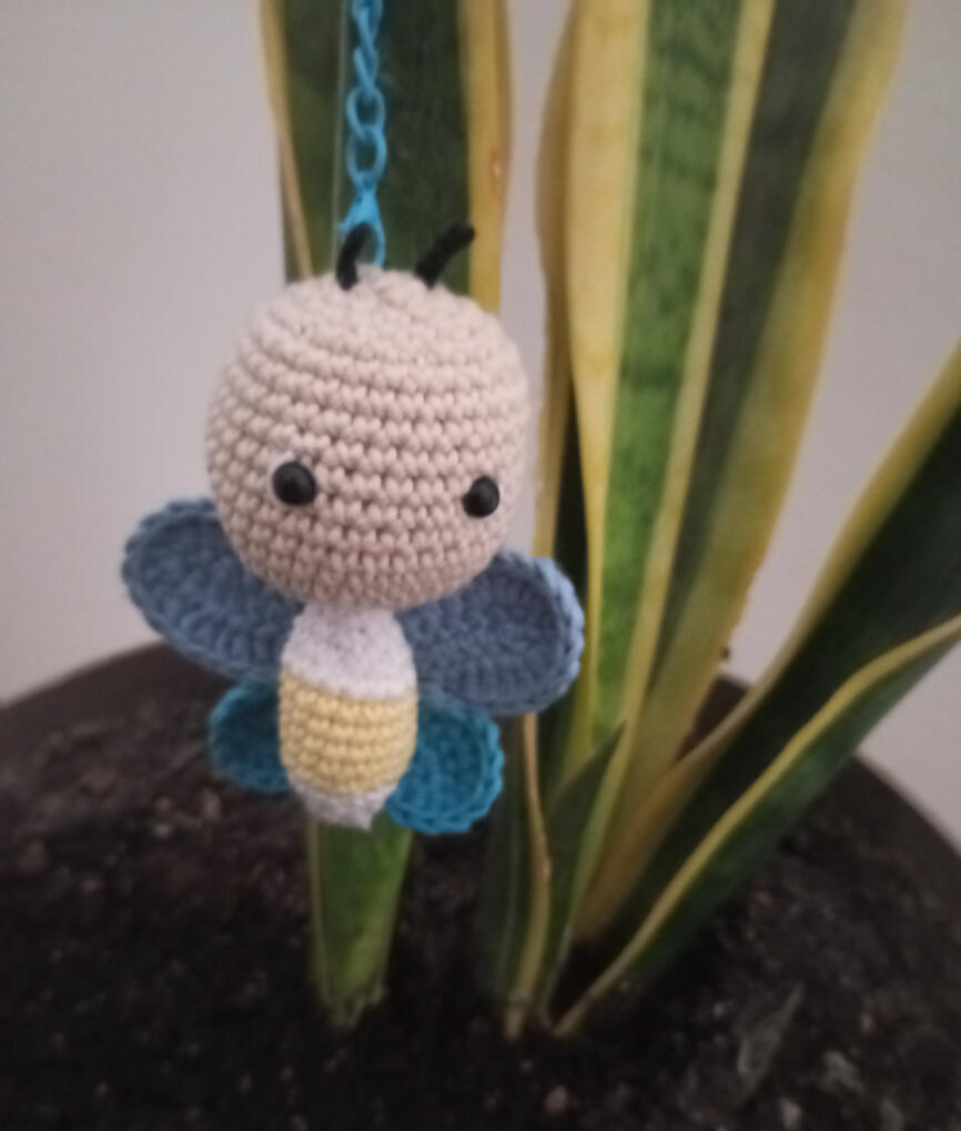 llavero con forma de abeja o mariposa colgado en una planta llavero con forma de abeja o mariposa colgado en una planta